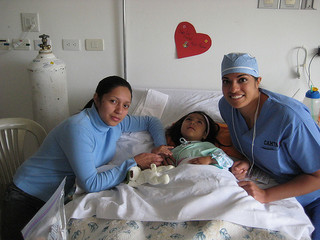 CAMTA staff comforting a young girl out of surgery. smiling all around