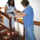 A CAMTA member helping a patient walk down the stairs using crutches