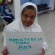 Older lady posing with a sign which says Maria Teresa Parra 887